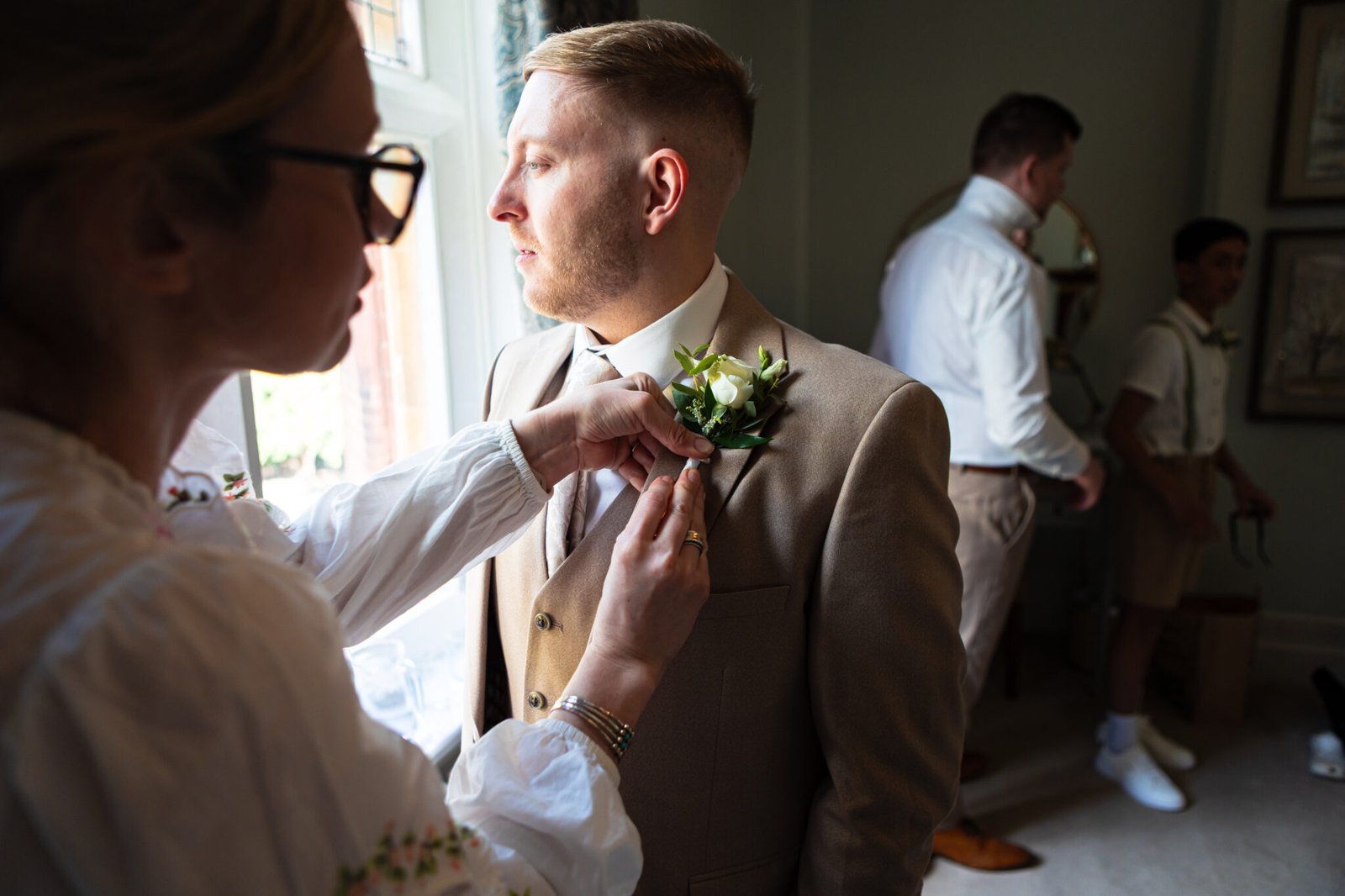 Groom preparations at Holmewood Hall captured by Cambridge wedding photographer