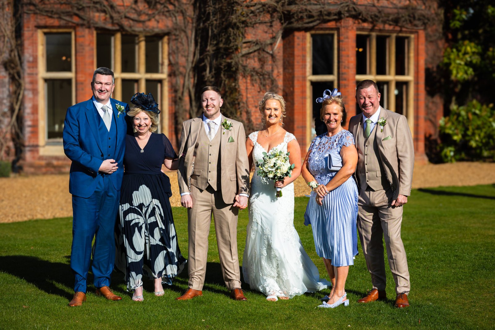 Guests celebrating outside Holmewood Hall wedding venue Natural wedding photography at Holmewood Hall